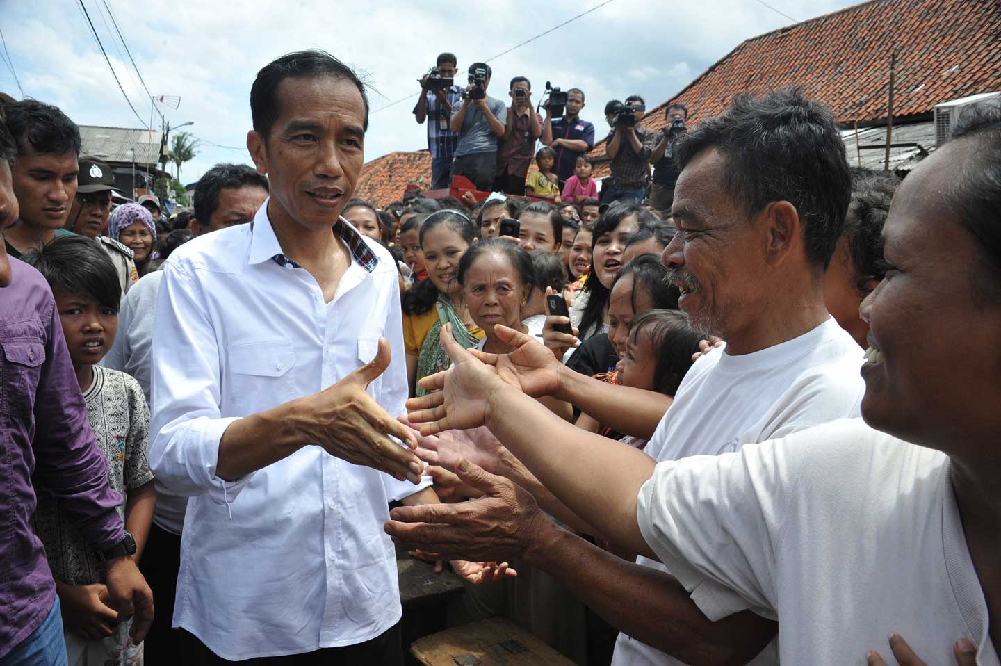 Indonesian President Joko “Jokowi” Widodo shaking hands with people on the street