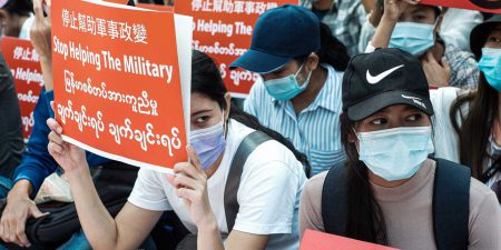 Protesters holding signs and wearing face masks in Myanmar