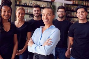 Six employees of a restaurant standing together and smiling