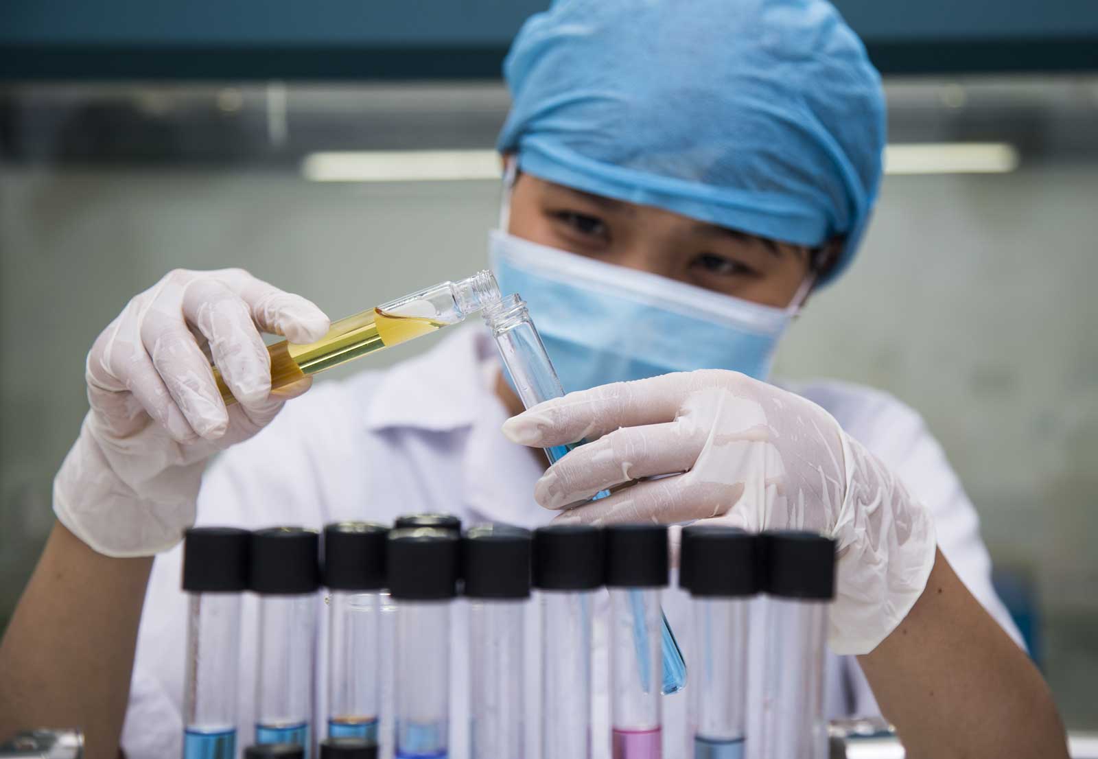 A lab technician pouring liquid into a vial